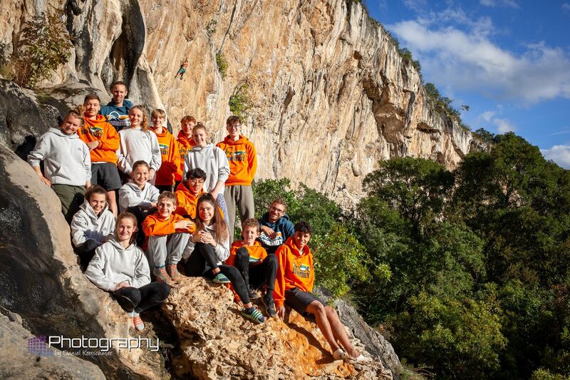 Gruppenfoto von den Teilnehmern der Bayernkaderfahrt vor den Felsen des Klettergebiets